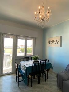 a dining room with a table and chairs and a chandelier at Ravenna d Amare 2 in Marina di Ravenna