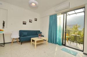 a living room with a blue couch and a window at Apartments Spasoje in Kotor
