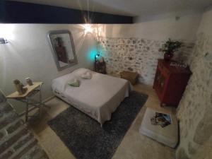a bedroom with a large bed in a room with stone walls at La croisée des destins in Viviers +5 photos