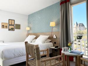 a hotel room with a bed and a window at Hôtel Beau Soleil in Pornic