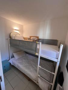 Un dormitorio con dos literas en una habitación. en a 2 minutes de la plage vue mer et piscine, en Cannes