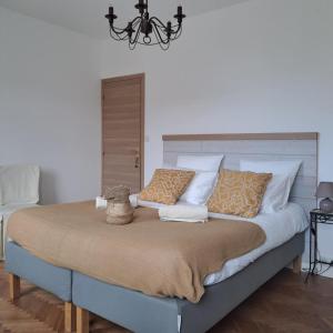 a bedroom with a large bed with white and orange pillows at Chambres Le Lac in Cherrueix +52 photos