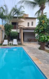 a villa with a swimming pool and a house at Casa em Ponta Negra in Natal