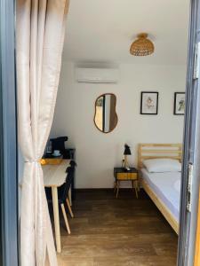 a bedroom with a bed and a desk and a table at Daro tiny house in Vama Veche