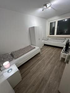 a room with two beds and a large window at 3 Zimmer Standard Apartment - 7 Betten - 2 x Badezimmer in Wolfsburg +2 photos