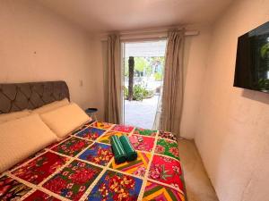 a bedroom with a bed with a colorful blanket on it at Suite 4 - Village Capixaba in Gravatá