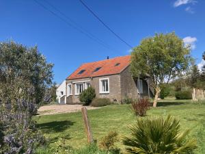 a house with an orange roof on a green yard at La Maison de Marin in Surtainville