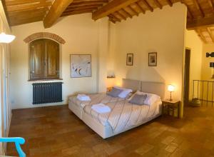 a bedroom with a large bed in a room at Podere Il Conventino, Casette in campagna con piscina in Nottola