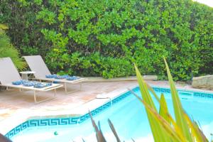 une piscine avec deux chaises longues à côté dans l'établissement Villa Adeona - Luxury House Valbonne - Pool - AC, à Valbonne