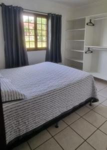a large bed in a bedroom with a window at Casa em Ponta Negra in Natal