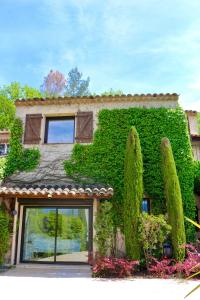un bâtiment recouvert de lierre vert avec des arbres dans l'établissement Villa Adeona - Luxury House Valbonne - Pool - AC, à Valbonne