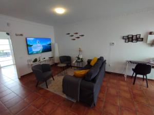 a living room with a couch and a flat screen tv at Casa 35 Barrio El Charco Puerto del Rosario in Puerto del Rosario