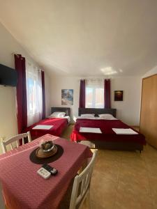 un soggiorno con 2 letti e un tavolo con sidro da tavolo. di Starlight Apartments a Ulcinj