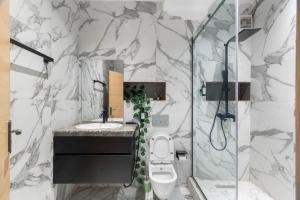 a bathroom with a toilet and a sink and a shower at Unique one bedroom apartment in Ilado