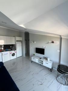 a white living room with a tv and a kitchen at SideByLotus in Side