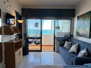 a living room with a blue couch and a view of the ocean at Estúdio Azul-T0-Torralta-Ocean View by Aura in Alvor