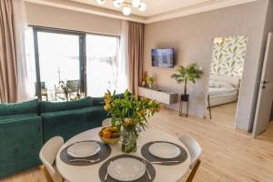 a living room with a table and a green couch at Apartamenty Boszkowo Horizon Sunrise in Boszkowo