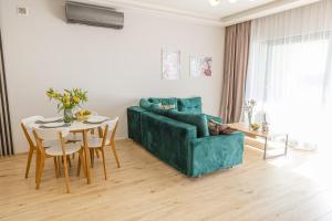 a living room with a green couch and a table at Apartamenty Boszkowo Horizon Sunrise in Boszkowo