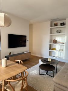 uma sala de estar com uma TV de tela plana na parede em Maison Dalaise - Cannes em Cannes