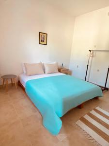 a large blue bed in a room with a table at Apartman Nela in Betina