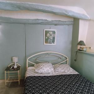 a bedroom with a bed with a metal canopy at apartement des Romains in Sospel