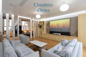 a living room with a couch and a flat screen tv at Ômarais Guest House in Paris