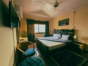 a small bedroom with a bed and a chair at Sapphire Lodges in Muzaffarabad +11 photos