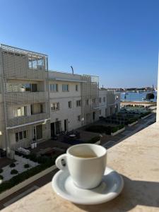 a cup of coffee sitting on top of a table at Apartment Belaj SeaSide Resort - Sea view in Umag