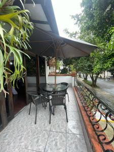 a table and chairs with an umbrella on a patio at Aguacatala Hotel Boutique in Medellín +98 photos