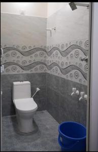 bagno con servizi igienici e secchio blu di M R Lodge a Tiruvannāmalai