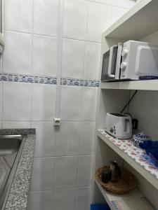 a small kitchen with white tiled walls and shelves at Estúdio Azul-T0-Torralta-Ocean View by Aura in Alvor +29 photos