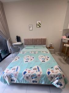 a bedroom with a large bed with a blue comforter at Skytrees 公寓 距Aeon五分钟路程 in Johor Bahru