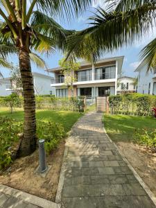 a palm tree and a walkway in front of a building at M Beach Luxury Villas Phu Quoc 2 in Phu Quoc +24 photos