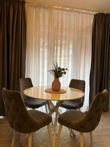 Una mesa con sillas y un jarrón de flores encima. en Budva APT, en Budva