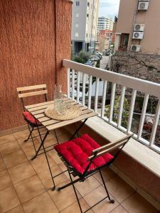 Una mesa y dos sillas en un balcón. en Budva APT, en Budva 1 foto más