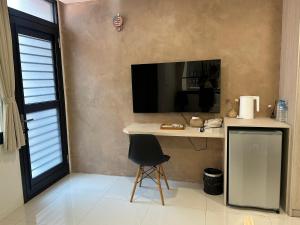 a room with a desk and a television on a wall at 隱居末巷 in San-fen-tzu