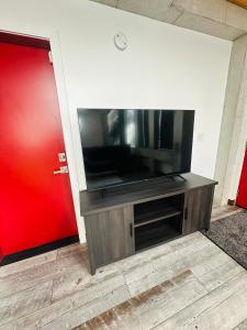 a flat screen tv on a entertainment center with a red door at Mary s house in Fairbanks