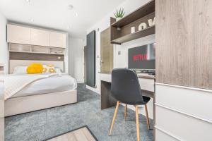 a bedroom with a bed and a desk with a chair at Contemporary Comfort Steps from Ricoh Arena in Coventry