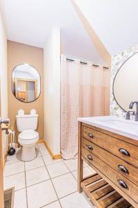 a bathroom with a toilet and a sink and a mirror at Whispering Pines Cabin in Whittier +20 photos