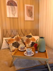 a coffee table with two cups and a vase on it at My Yellow House Casal in Campos do Jordão