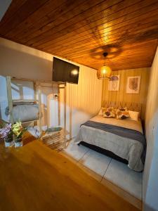 a bedroom with a bed with two cats laying on it at My Yellow House Casal in Campos do Jordão +6 photos