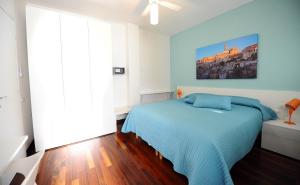 una camera con un letto blu e un dipinto sul muro di amaranto bnb a Matera