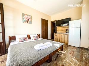 a bedroom with a large bed with towels on it at The Peaceful Villa in Paralia Dionysiou