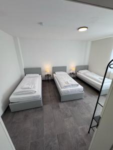 two beds in a small room with two lamps at Bavaria Home Apartment Rohrbach in Rohrbach