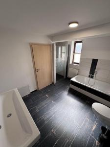 a bathroom with a tub and a toilet and a sink at Bavaria Home Apartment Rohrbach in Rohrbach +21 photos