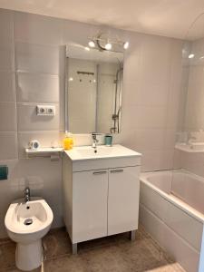 a bathroom with a sink and a toilet and a tub at Duplex B Vacaciones en el mar in Ribeira +30 photos
