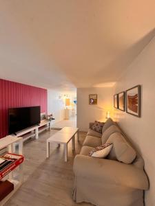ein Wohnzimmer mit Sofa und Fernseher in der Unterkunft Duplex B Vacaciones en el mar in Ribeira