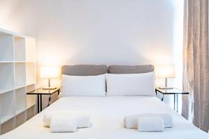 a bedroom with a white bed with two side tables at The Urban Studio Madrid in Madrid