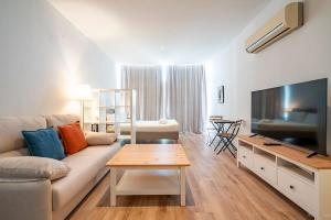 a living room with a couch and a flat screen tv at The Urban Studio Madrid in Madrid