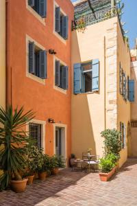 un edificio con tavoli e sedie in un cortile di The Peach House a Chania